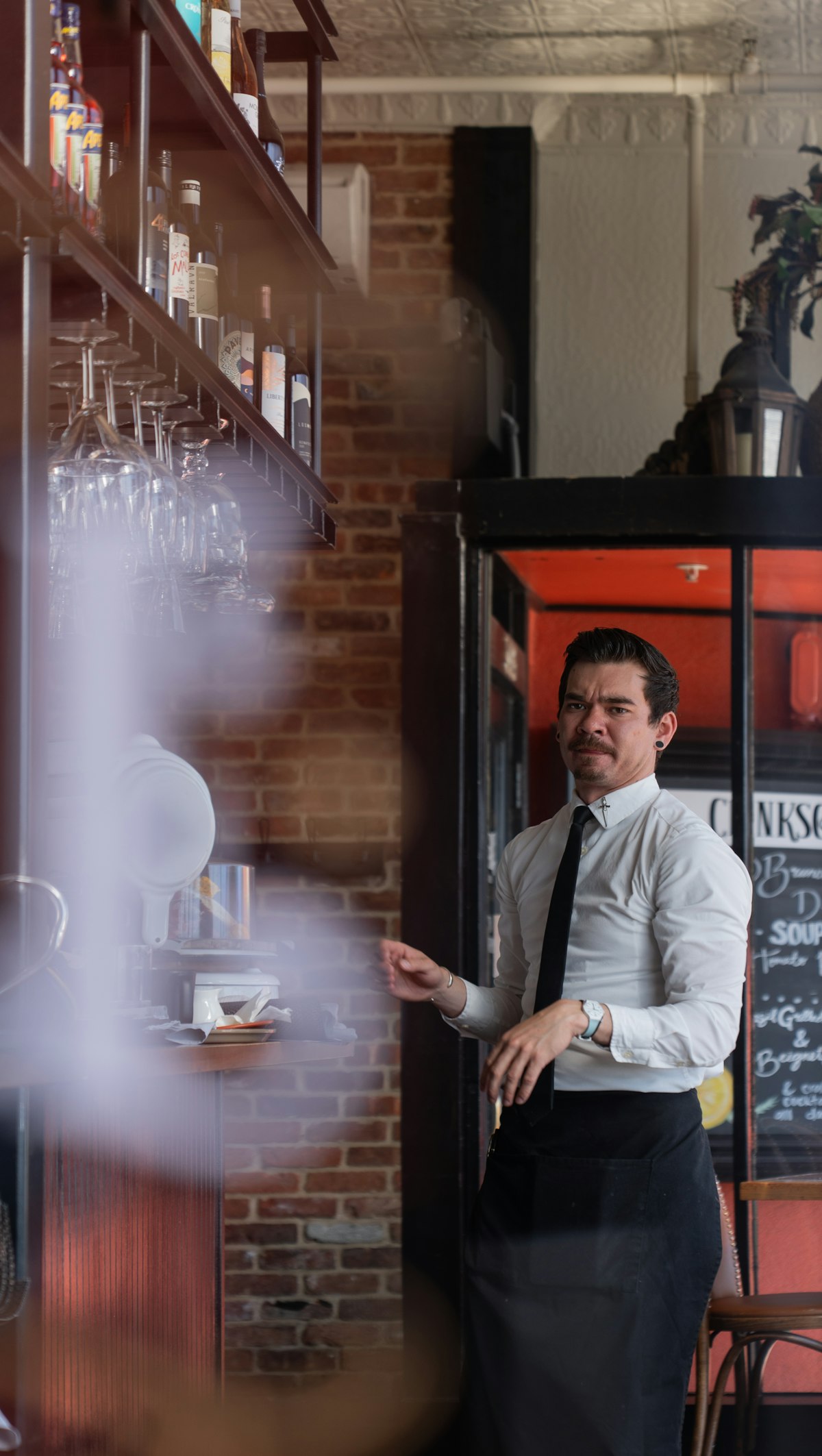Bartender nhà hàng mặc đồng phục áo sơ mi trắng và tạp dề đen